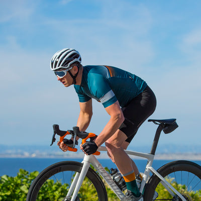 Roady cyclisng riding on Pacific Coast Highway wearing Bellwether Pinnacle Jersey and Newton Bib Shorts