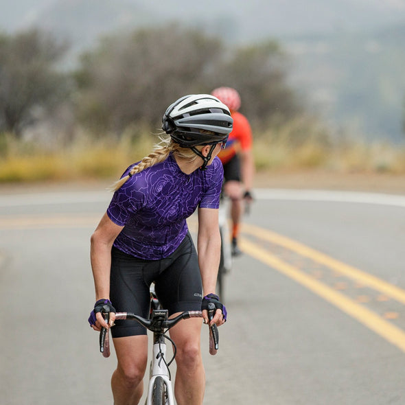 road cyclist wearing axiom halter bib short dropping another rider on a climb in malibu california