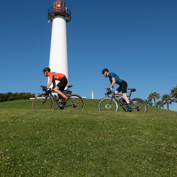 2 road cyclist climbing toward lighthouse in long beach, California 
